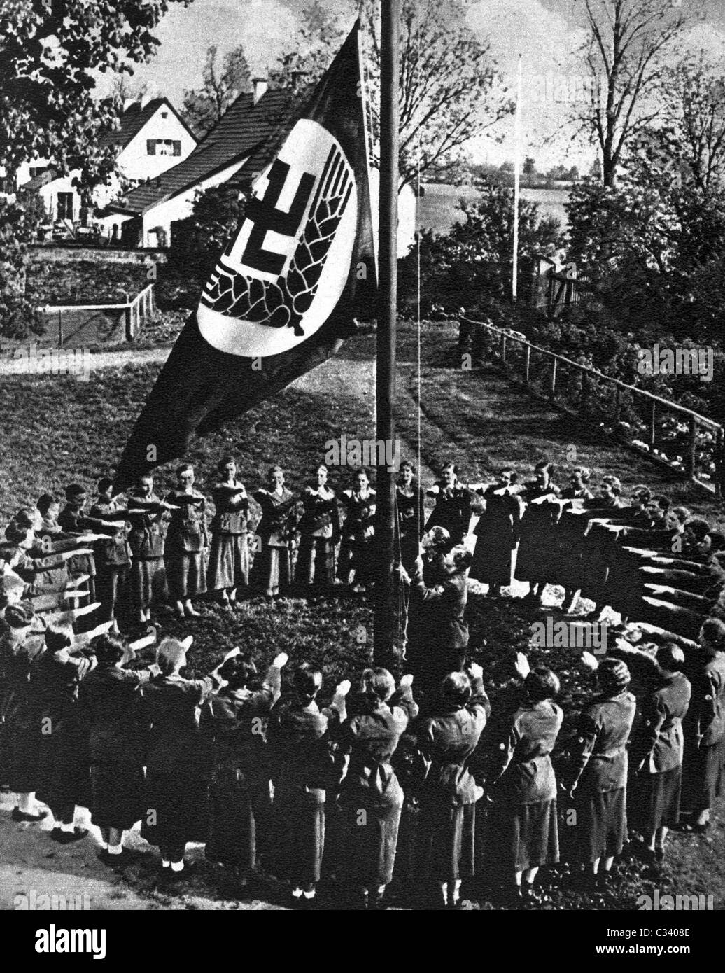 I membri RADWJ dare il saluto di Hitler a colori cerimonia, sollevando la bandiera RADWJ. Foto Stock