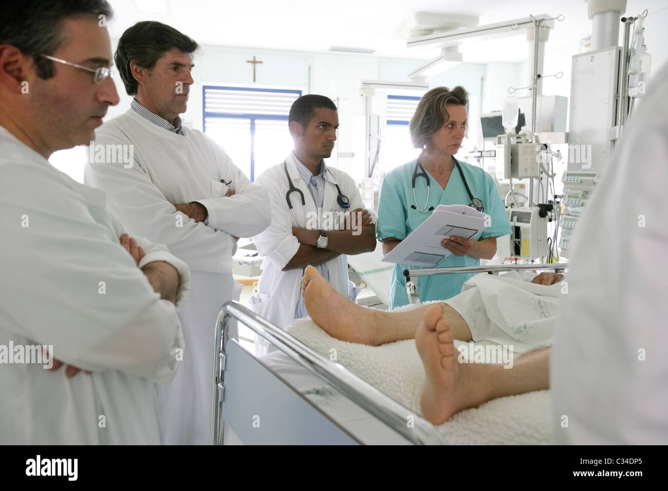 I medici e gli infermieri esame paziente in un letto di ospedale Foto Stock