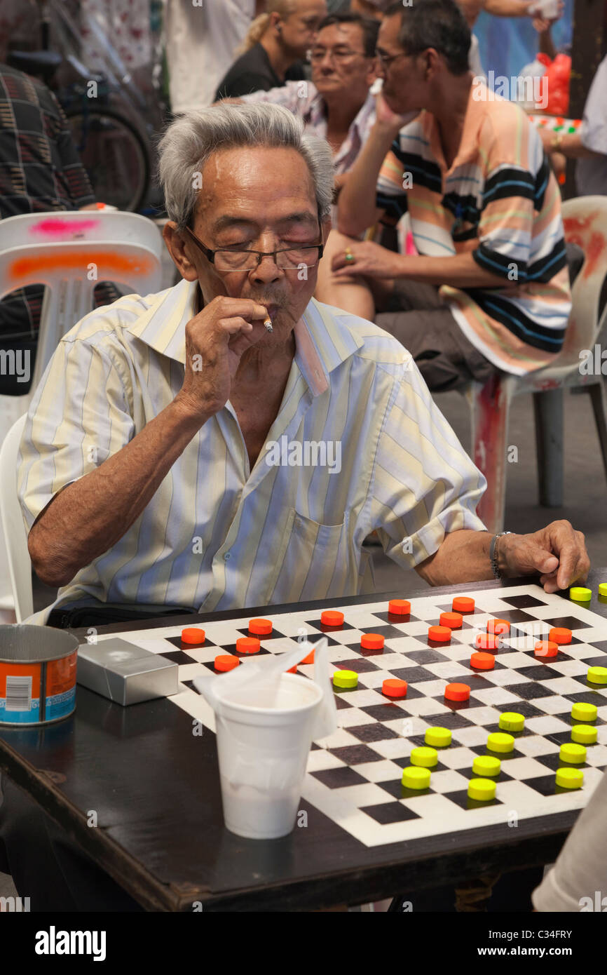 Chinatown, Singapore - smoking uomo giocando a Dama Foto Stock