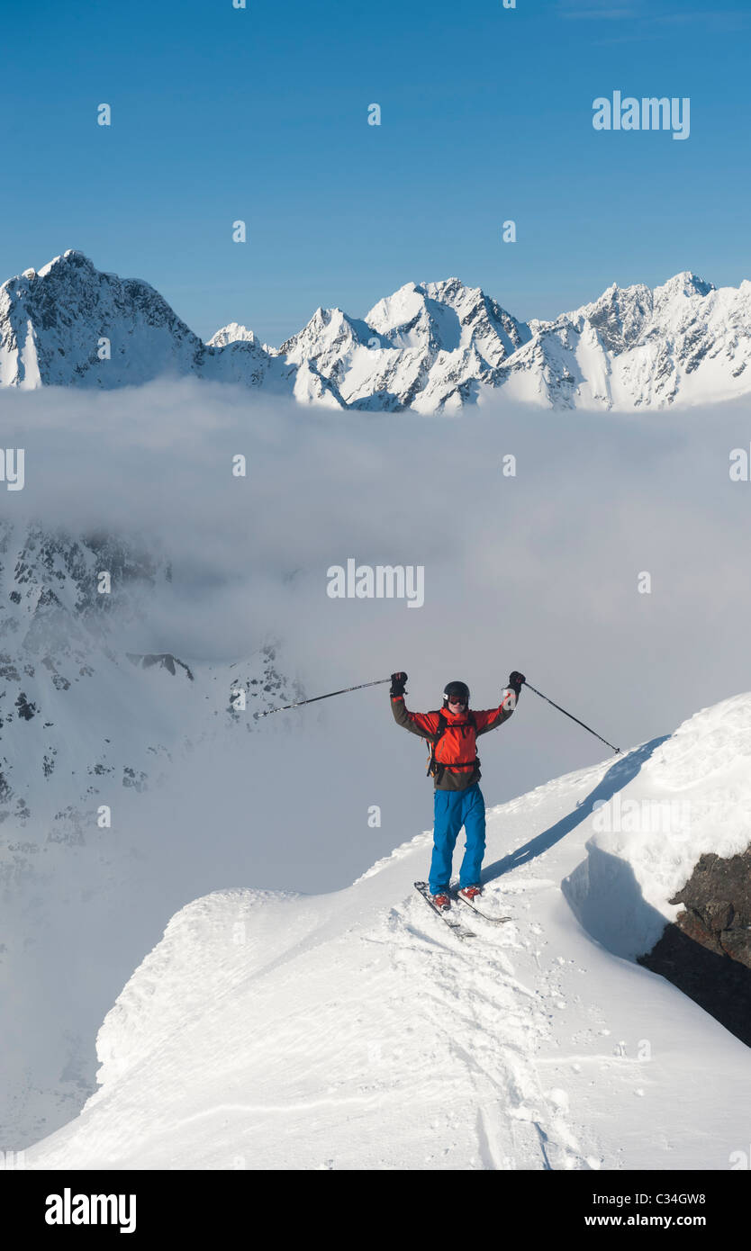 Sciatore libera sulla cima di una montagna ammirando la wintery paesaggio di montagna in Lyngen, Norvegia. Foto Stock