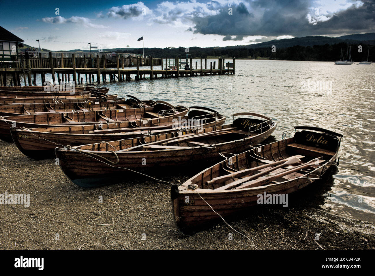 Barche a remi legate sulla riva del lago Windermere, Cumbria. Foto Stock