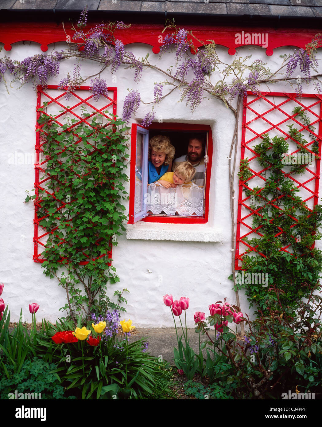 Co Kerry, Irlanda; famiglia guardare fuori dalla finestra del Cottage Foto Stock