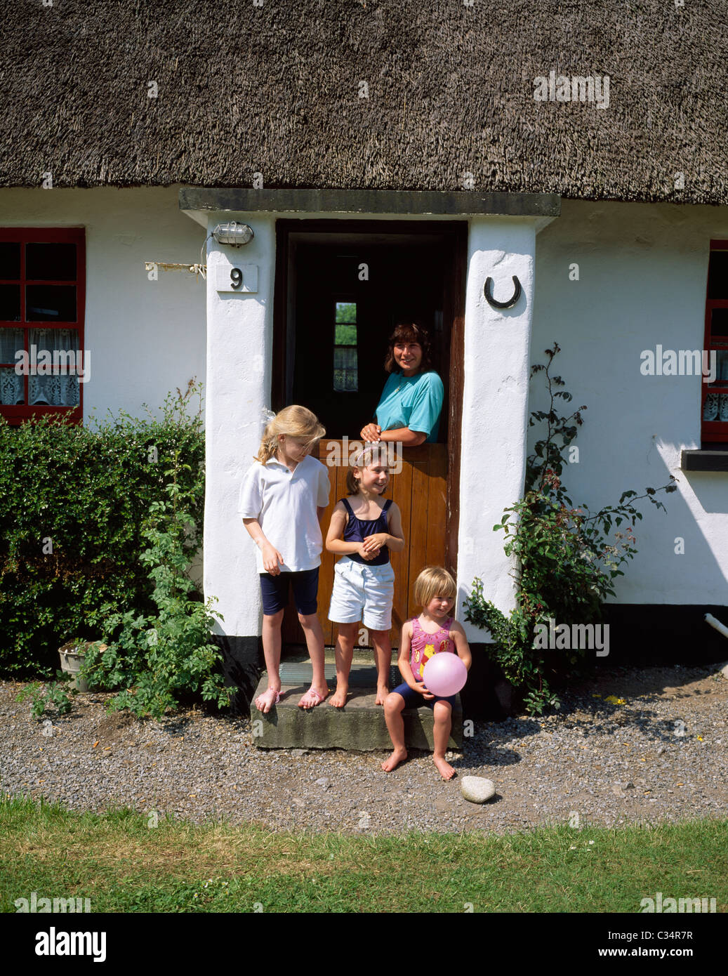 Puckaun,Co Tipperary, Irlanda;famiglia al di fuori del Cottage Foto Stock
