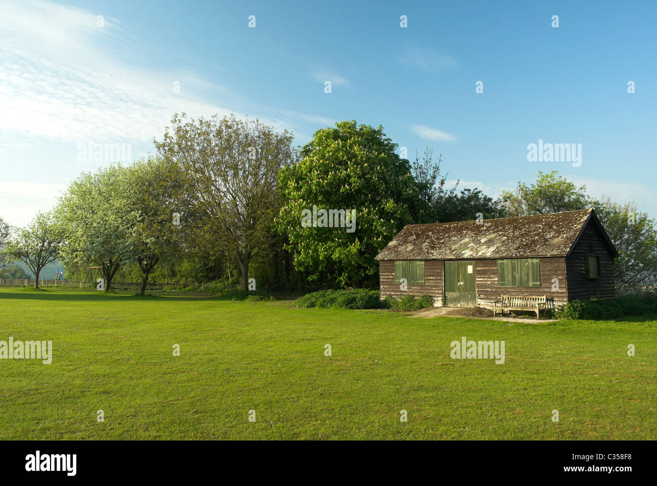 Burpham village green e il vecchio padiglione di cricket in primavera sole. Foto Stock