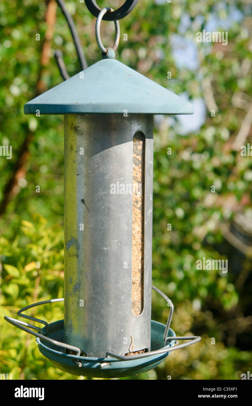 Metallo bird feeder piena di sementi Foto Stock