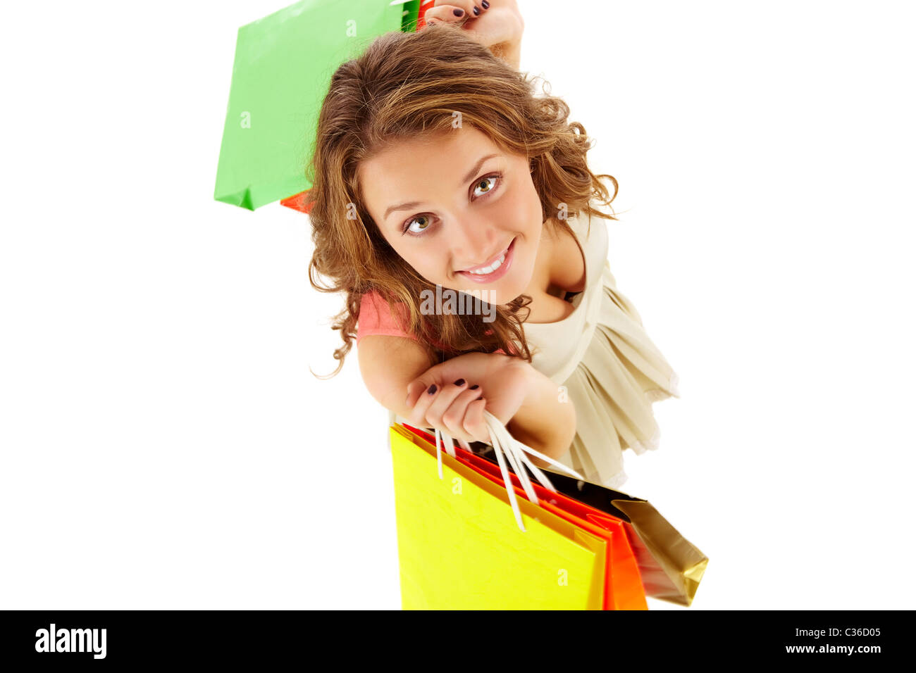 Al di sopra di angolo di una ragazza con sacchetti di carta guardando la fotocamera e sorridente Foto Stock