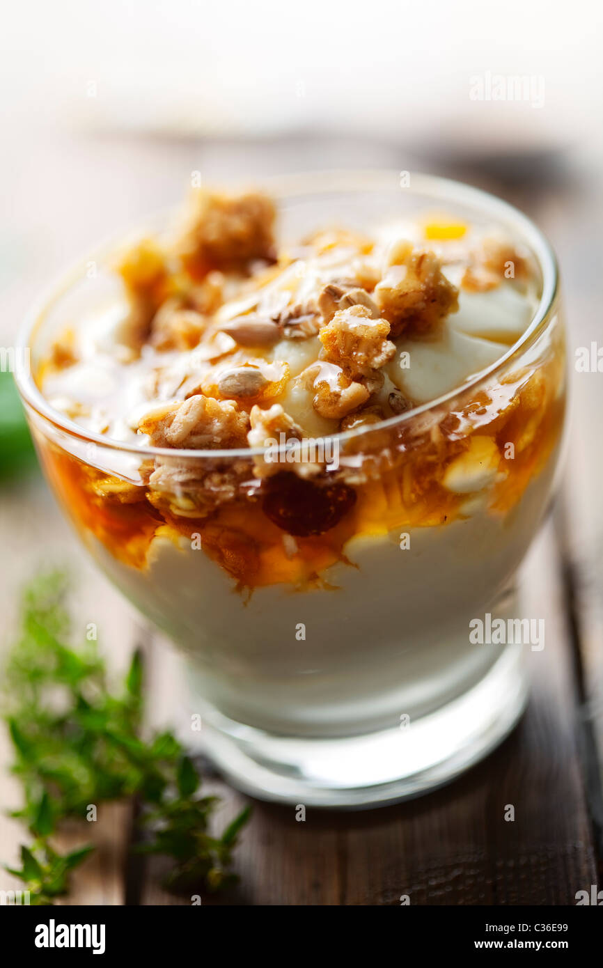 Close up di yogurt greco con golden miele selvatico e musli Foto Stock