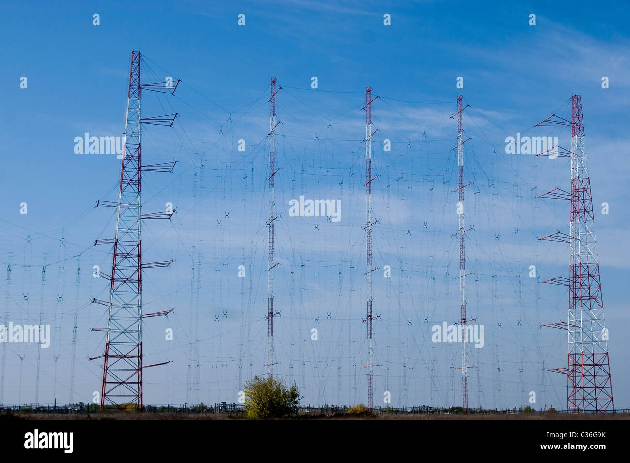 Blue sky impostazione dietro una fila di piloni di elettricità Foto Stock