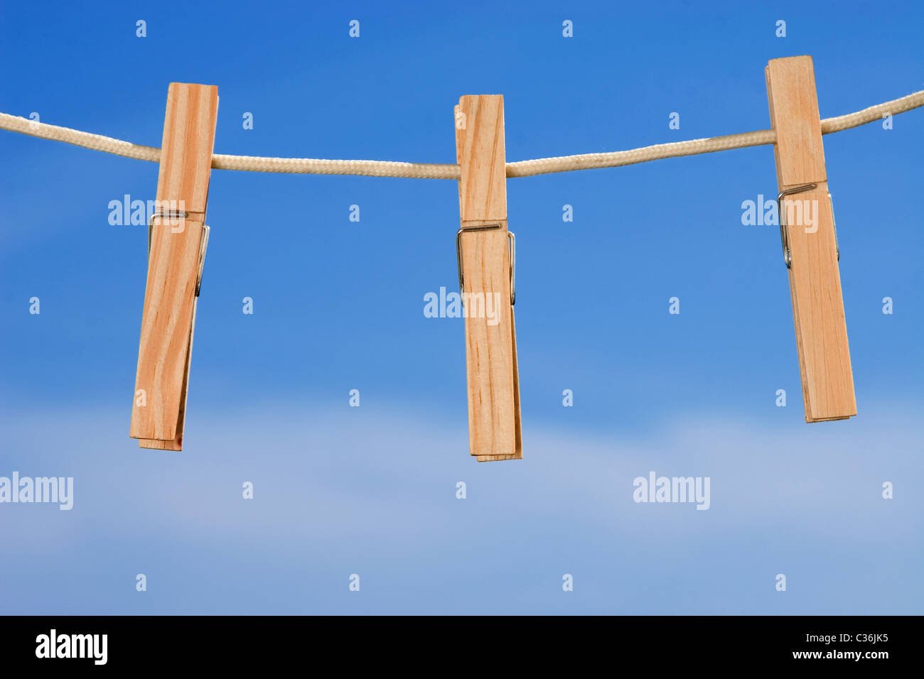 Vestiti-linea e pioli sul cielo blu sullo sfondo Foto Stock