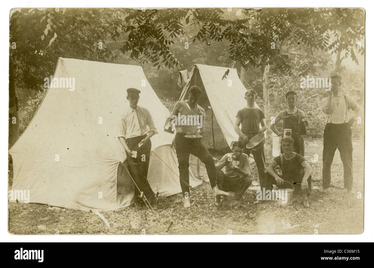 Circa 1910s real-photo Cartolina postale che mostra un gruppo di 7 uomini camping. Foto Stock
