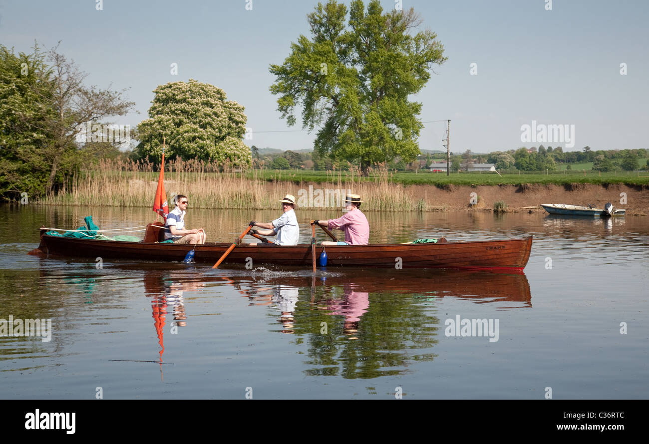 Tre uomini in una barca a remi in barca sul fiume Tamigi a Wallingford Oxfordshire UK Foto Stock