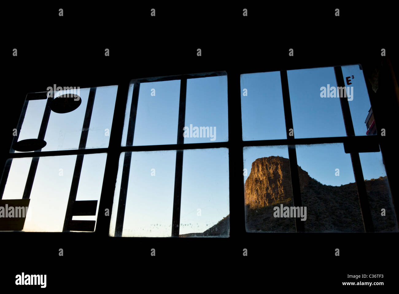 La luce solare che colpisce la montagna visto attraverso la finestra del ristorante al Theodore Roosevelt lago vicino Phoeniz Arizona, Stati Uniti. Foto Stock