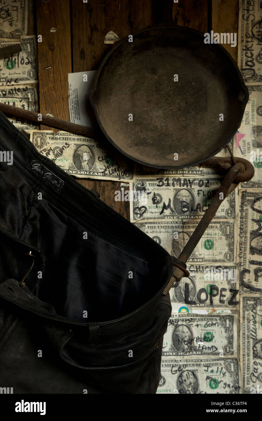 US Dollar Bills postato su una parete di un ristorante con una padella di ferro e jeans scoloriti a Theodore Roosevelt Lake, Arizona, Stati Uniti. Foto Stock