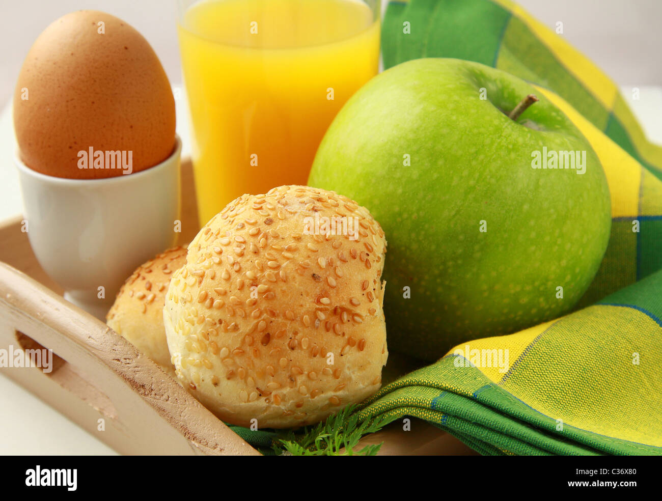 La prima colazione con succo d'arancia, uova sode e ciambelle di sesamo e mela verde Foto Stock