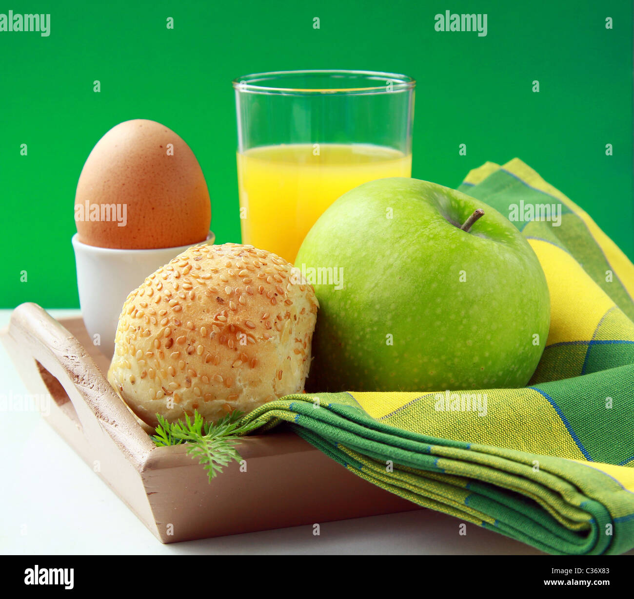 La prima colazione con succo d'arancia, uova sode e ciambelle di sesamo e mela verde Foto Stock