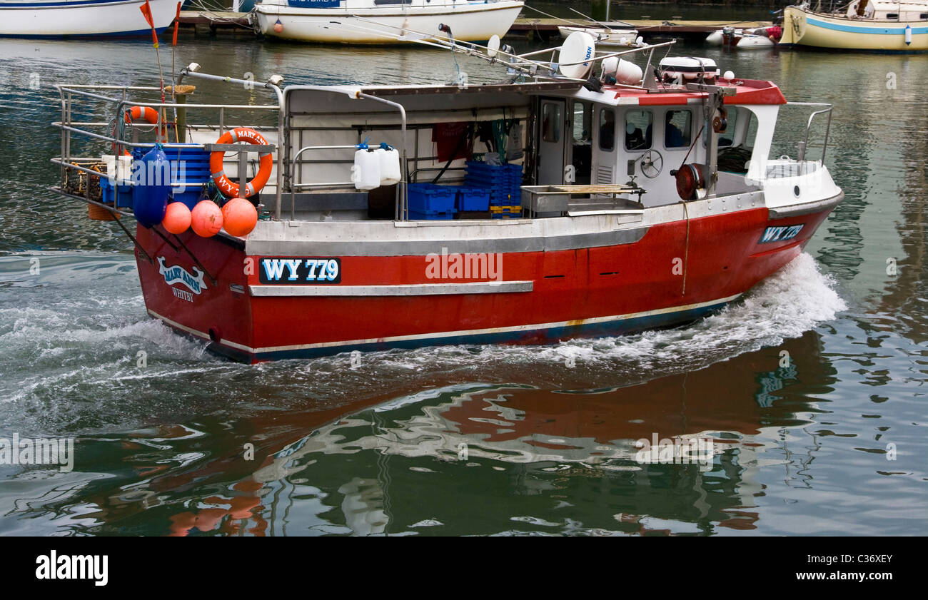 Piccola barca da pesca a strascico di lasciare il porto di Whitby North Yorkshire Inghilterra Europa Foto Stock
