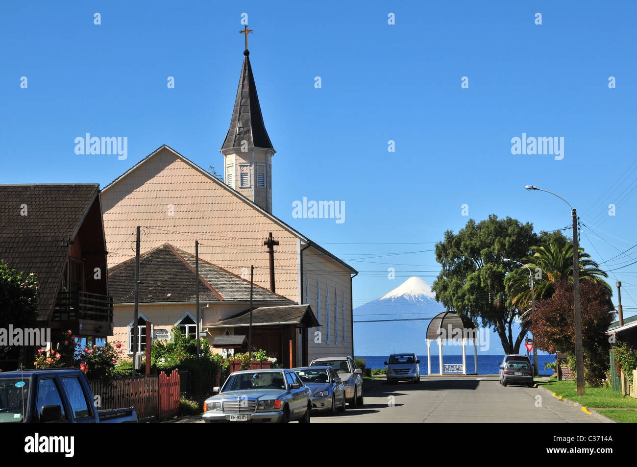 Auto parcheggiata su una strada da scandole di legno chiesa luterana, guardando verso il Lago Llanquihue e Volcan Osorno, Frutillar, Cile Foto Stock