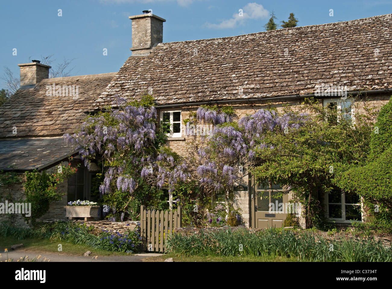 Vecchio cottage in pietra con il glicine, Southrop, nel Gloucestershire. Cotswolds, UK. Foto Stock