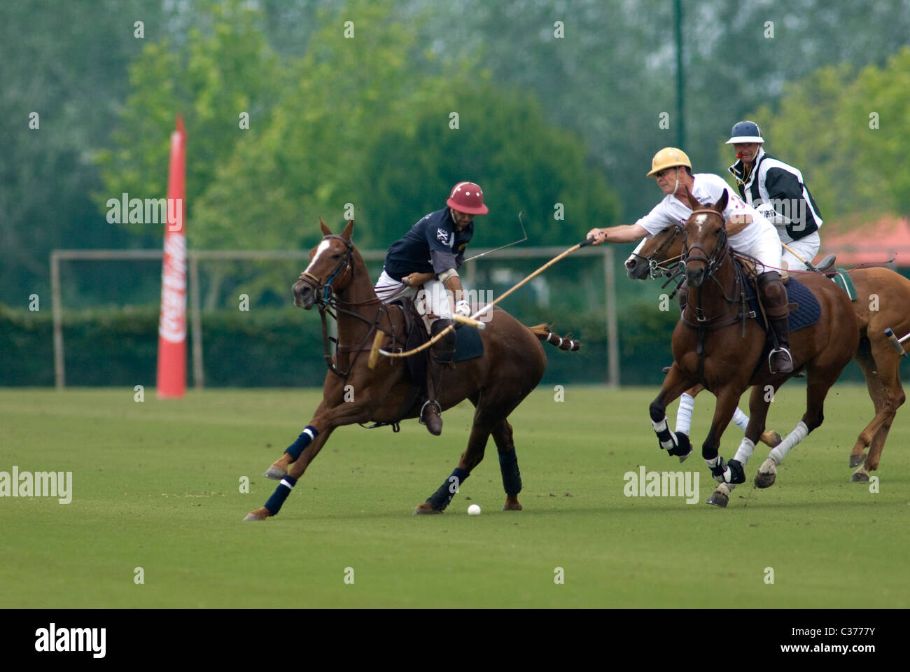 2 giocatori di Polo in azione con arbitro dietro Foto Stock
