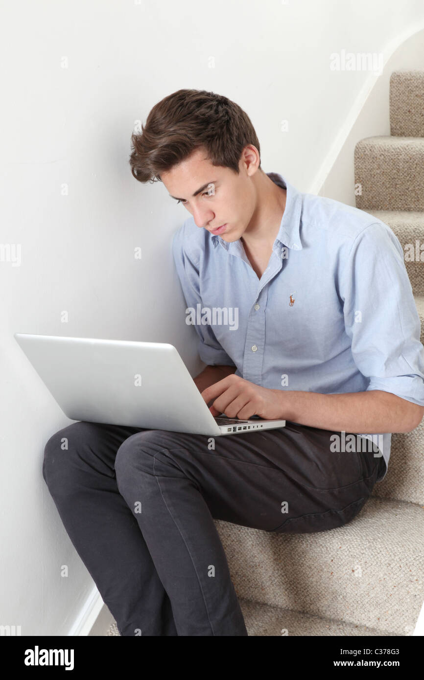 Giovane maschio usando il suo computer portatile. Foto Stock