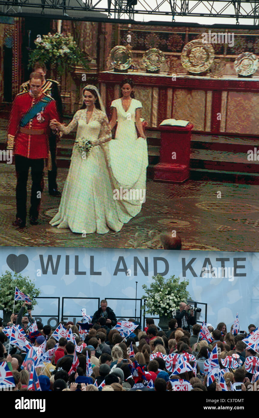 Il 29 aprile 2011 Royal Wedding su schermo televisivo gigante Trafalgar Square guardato da grande folla. Foto Stock