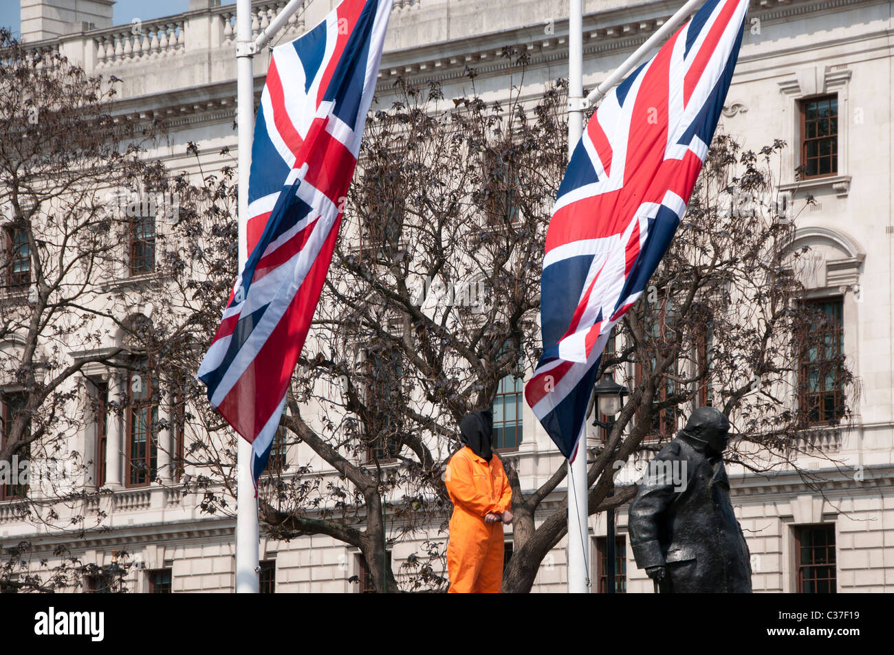 Londra Aprile 2011. Protesta di fronte al parlamento con protester vestito in arancione Guantamano prigione uniforme e unione dei martinetti Foto Stock