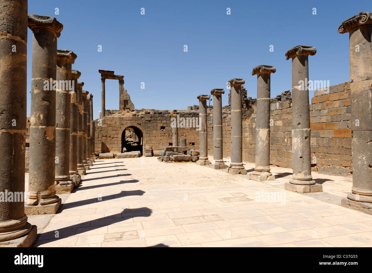 Bosra. La Siria. Vista di una rettangolare di epoca romana o cortile Palaestra circondato da colonne. Foto Stock