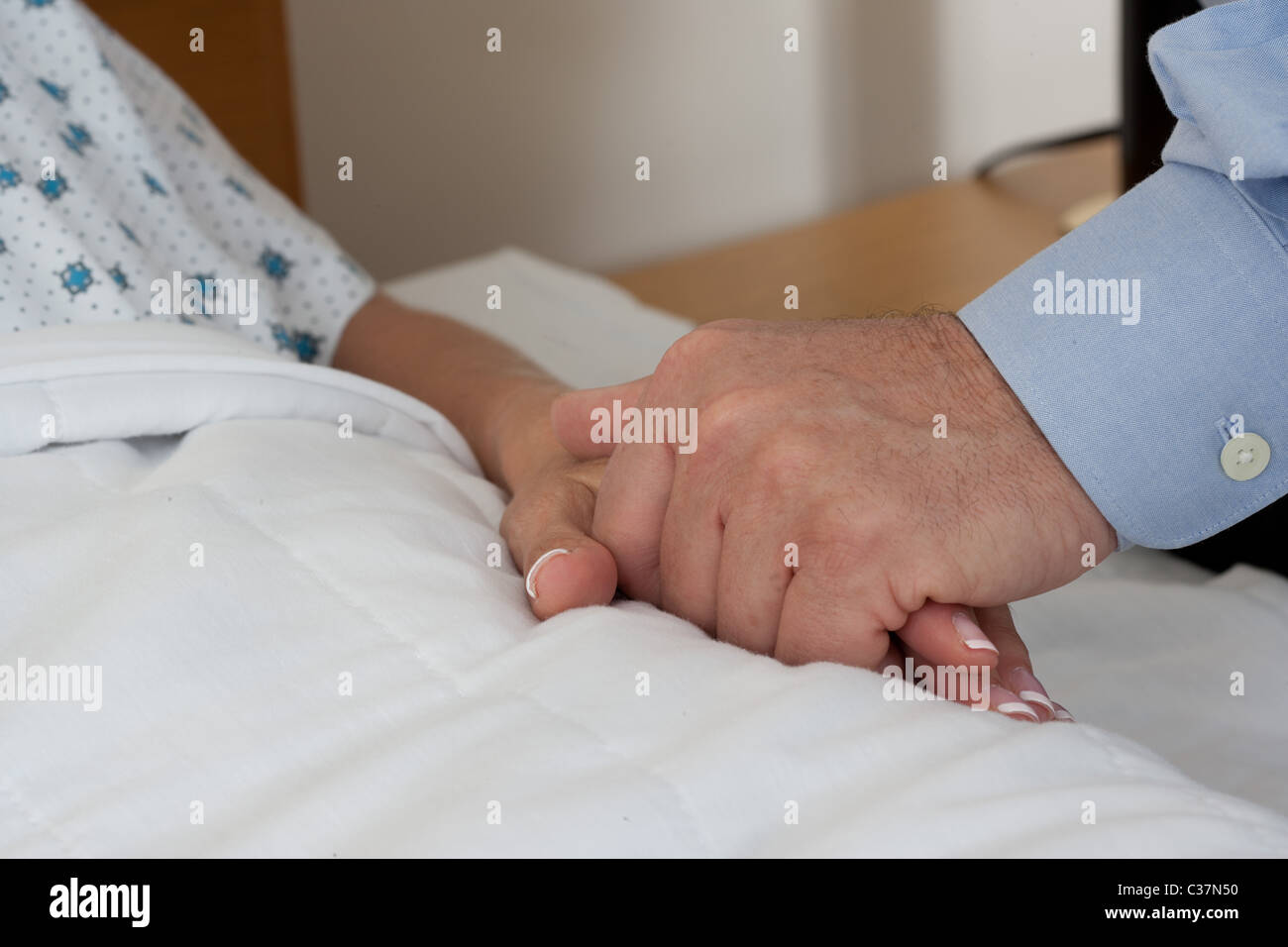 Close-up del giovane tenendo le mani durante il ricovero in ospedale Foto Stock