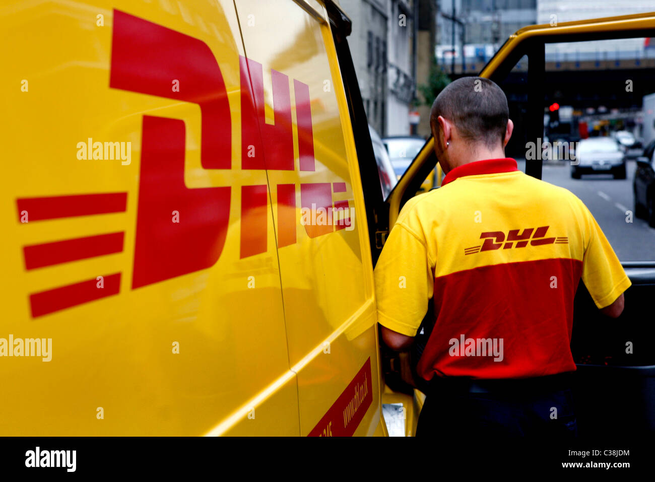 Un DHL van conducente si prepara a effettuare una consegna. Foto Stock