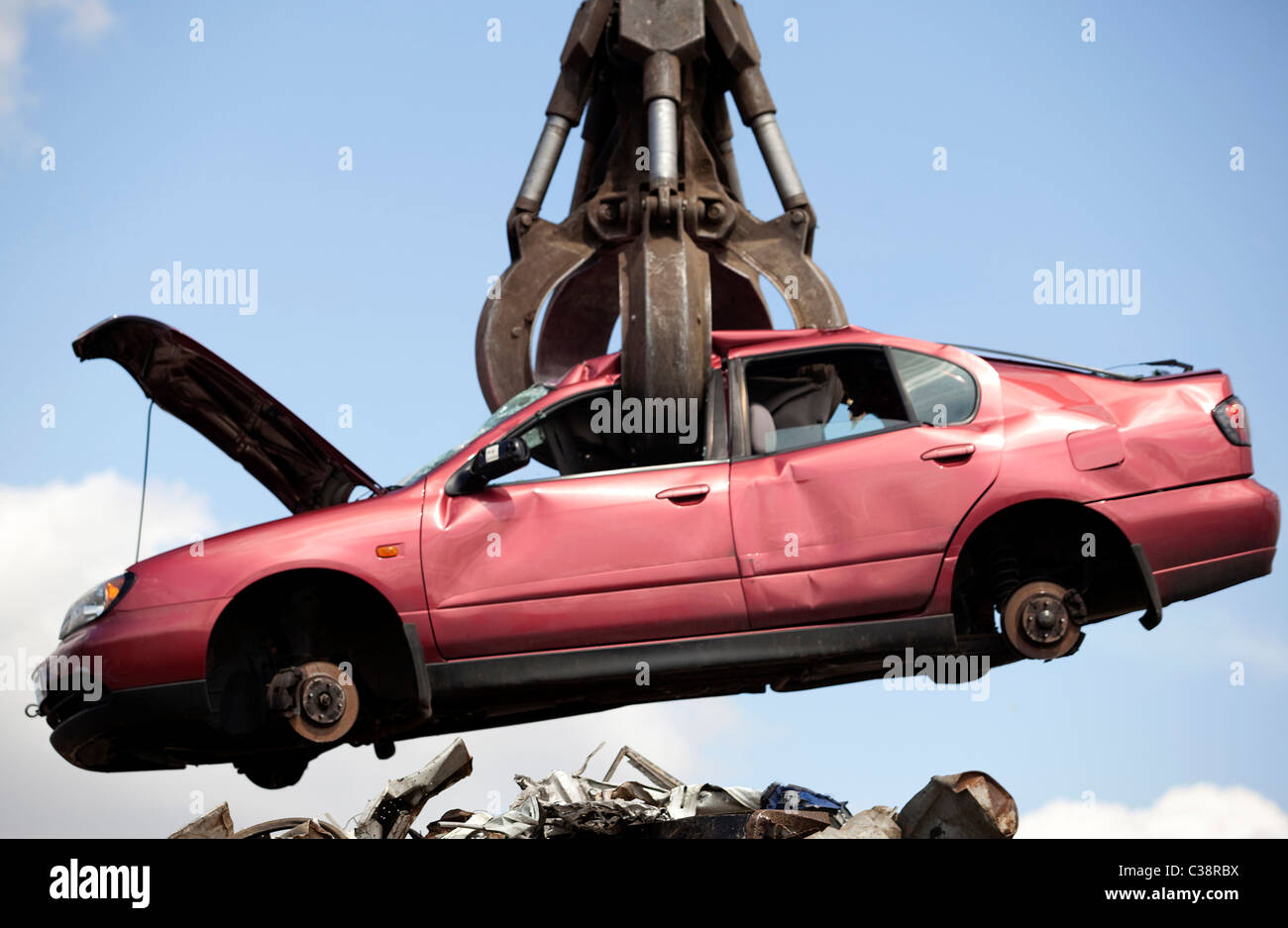 Una macchina Nissan è prelevato da una gru in un'immagine illustrativa di un scrapyard. Foto Stock