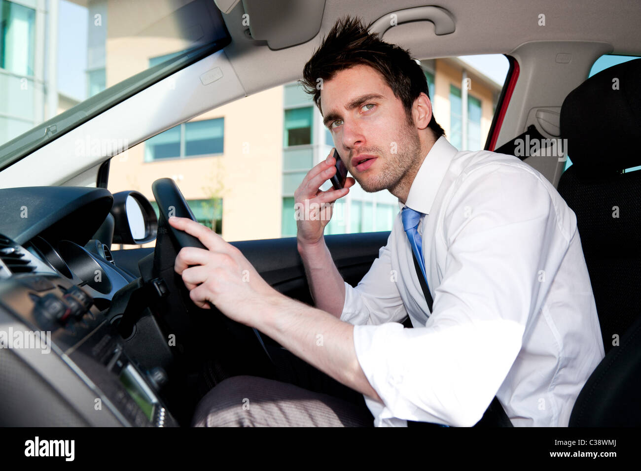 Uomo che parla al telefono in auto Foto Stock