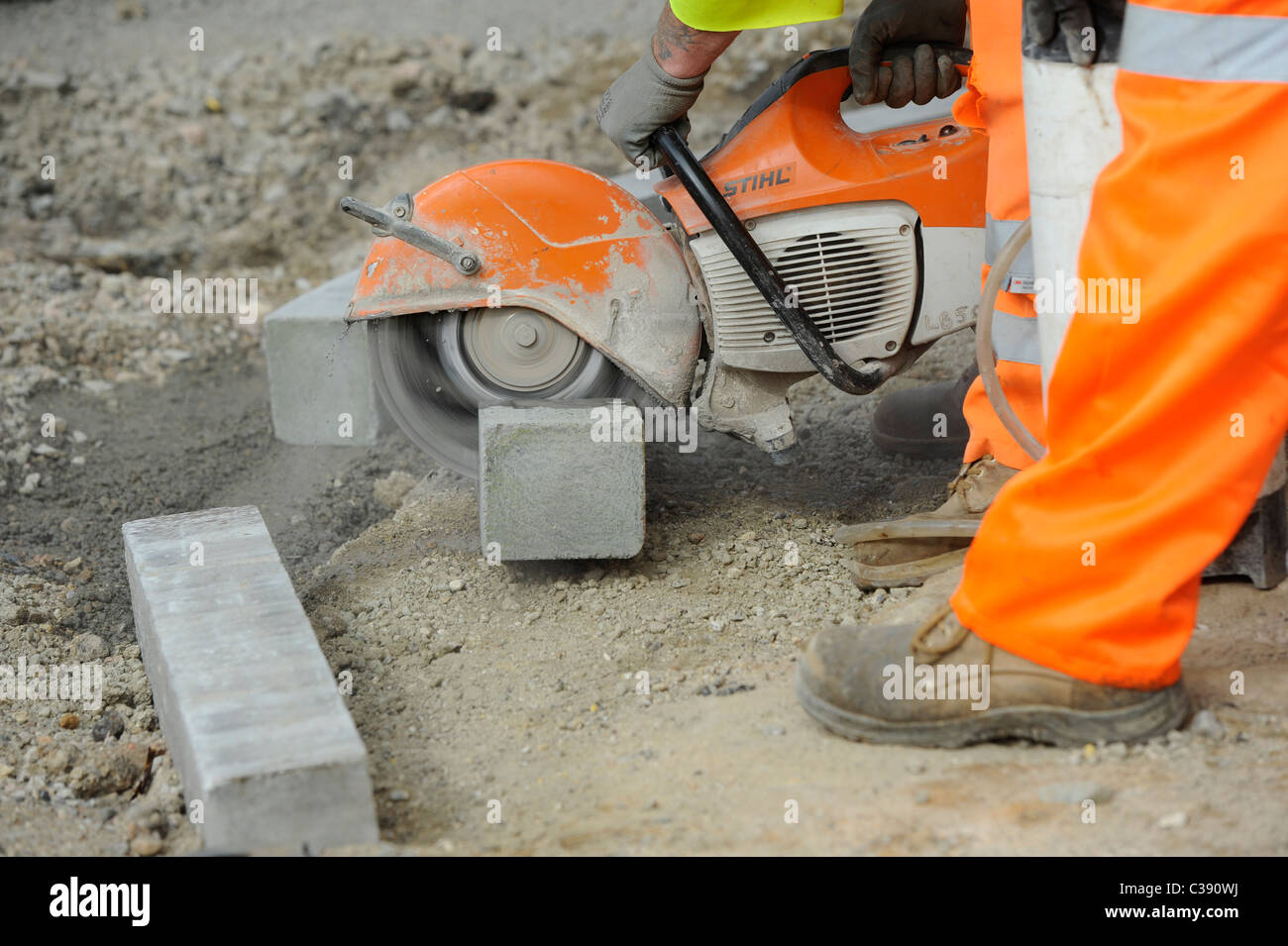 Roadworks: lavoratori utilizzano pietra apparecchiature di taglio di pavimentazione laici in East Sussex. Foto Stock