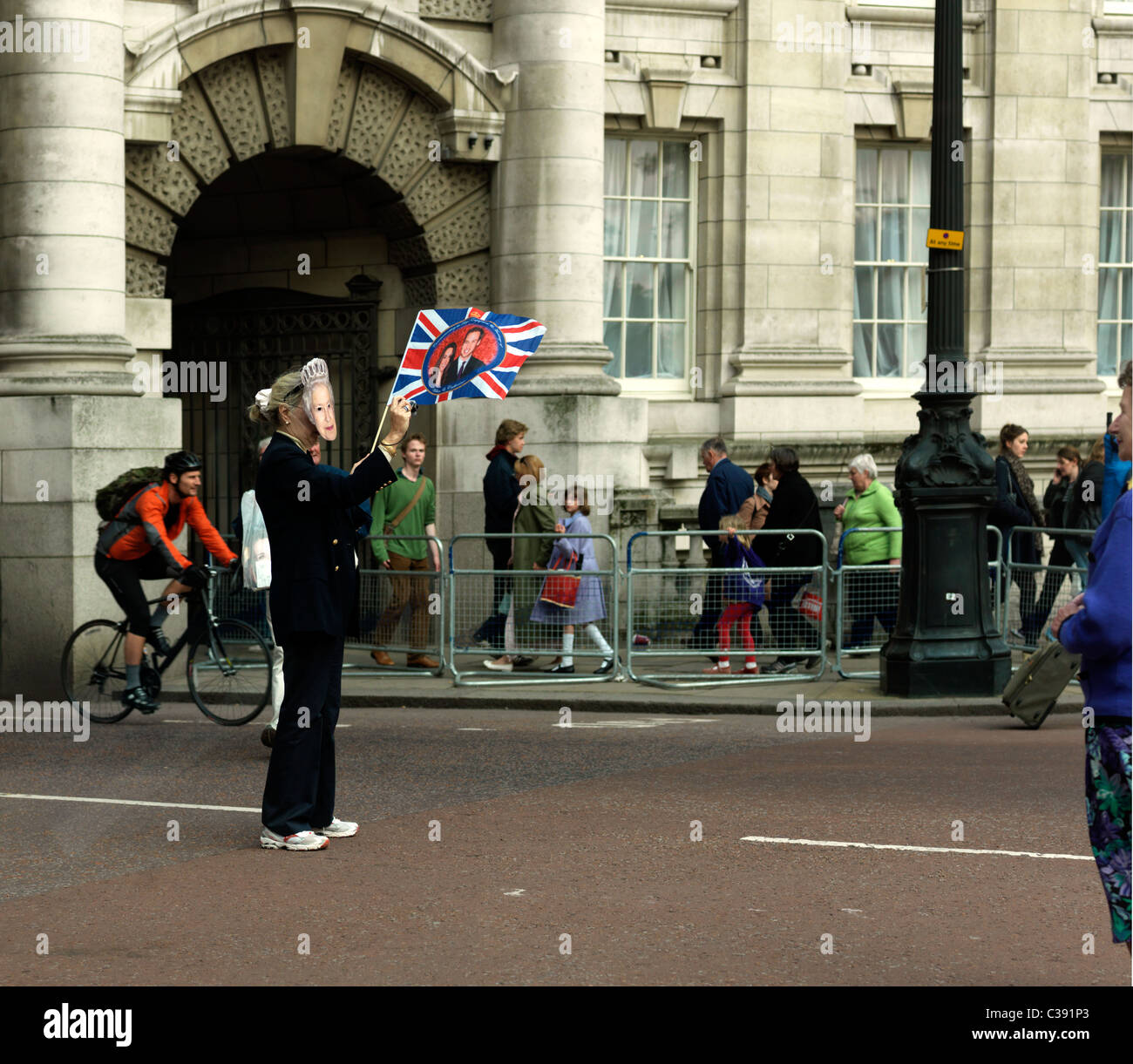 Royal Wedding Tourist indossare una maschera della regina di scattare una foto mentre sventola una bandiera Foto Stock