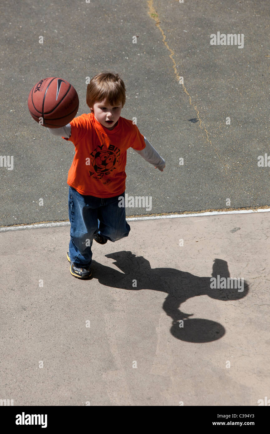 Giovane ragazzo giocando street basket in Riverside Park, New York City. Foto Stock