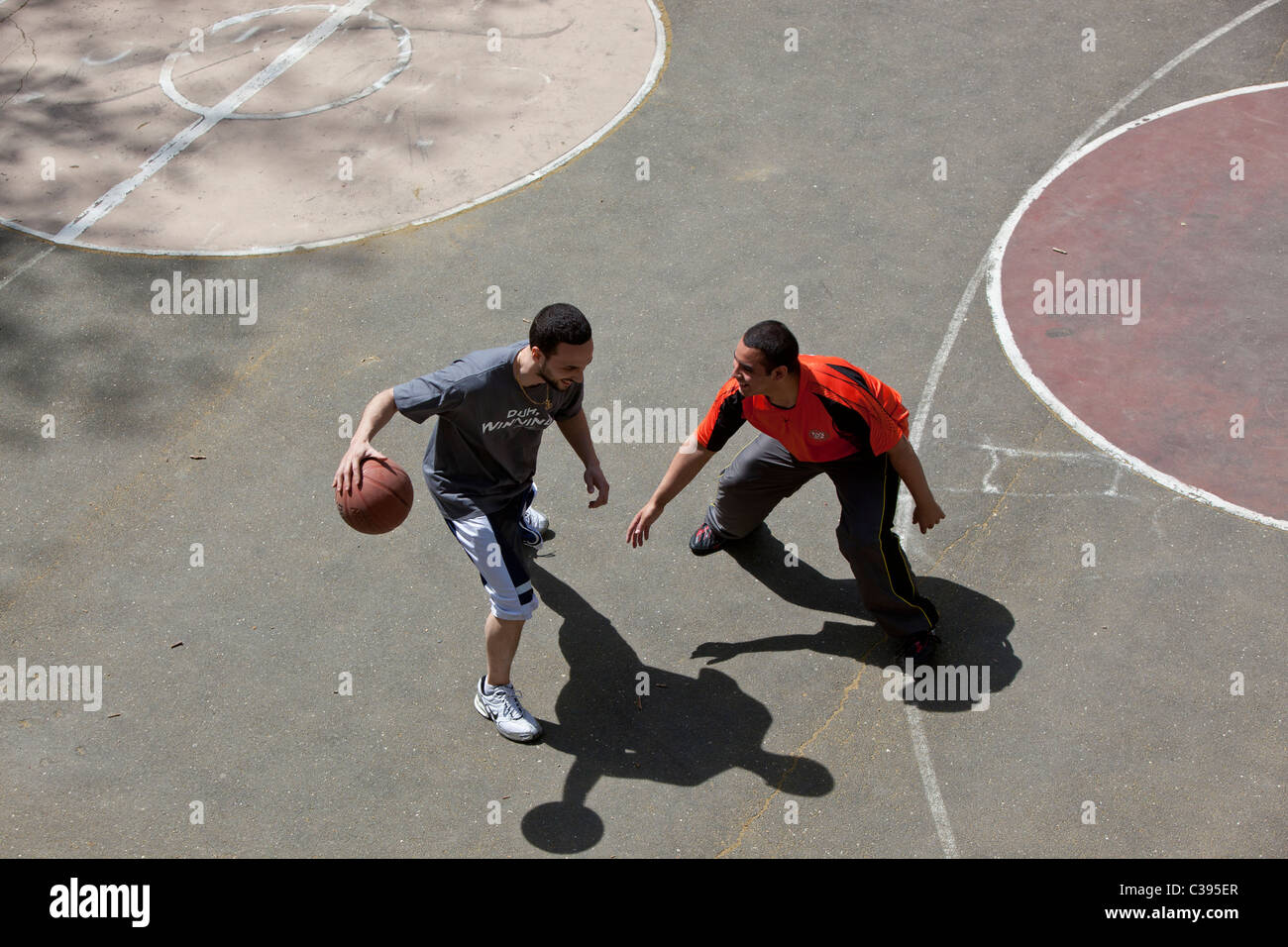 I giovani adulti giocando street basket in Riverside Park, New York City. Foto Stock