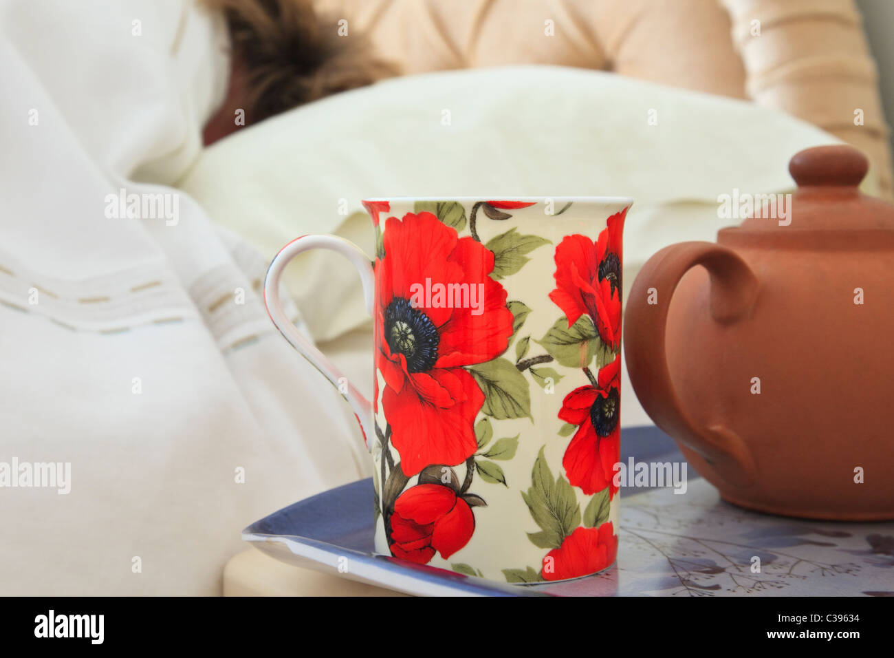 Immagine di tutti i giorni di mattina una tazza di tè e teiera su un comodino con una persona che dormiva nel letto avente un piumone giornata a casa. Inghilterra Regno Unito Gran Bretagna Foto Stock