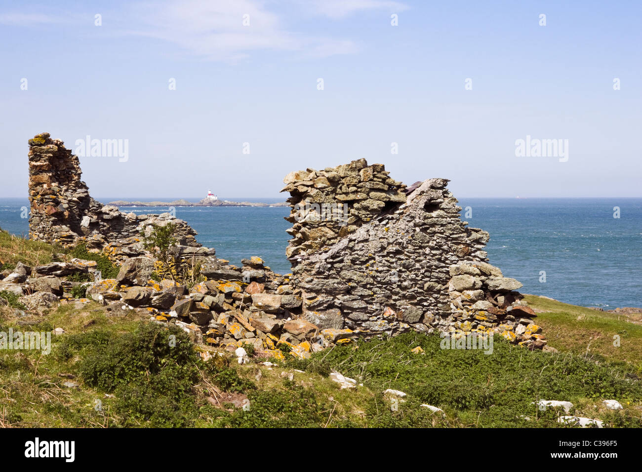Il carmelo di testa, Isola di Anglesey, Galles del Nord, Regno Unito. Vista la Skerries (Ynysoedd y Moelrhoniaid) attraverso rovinato mine building Foto Stock