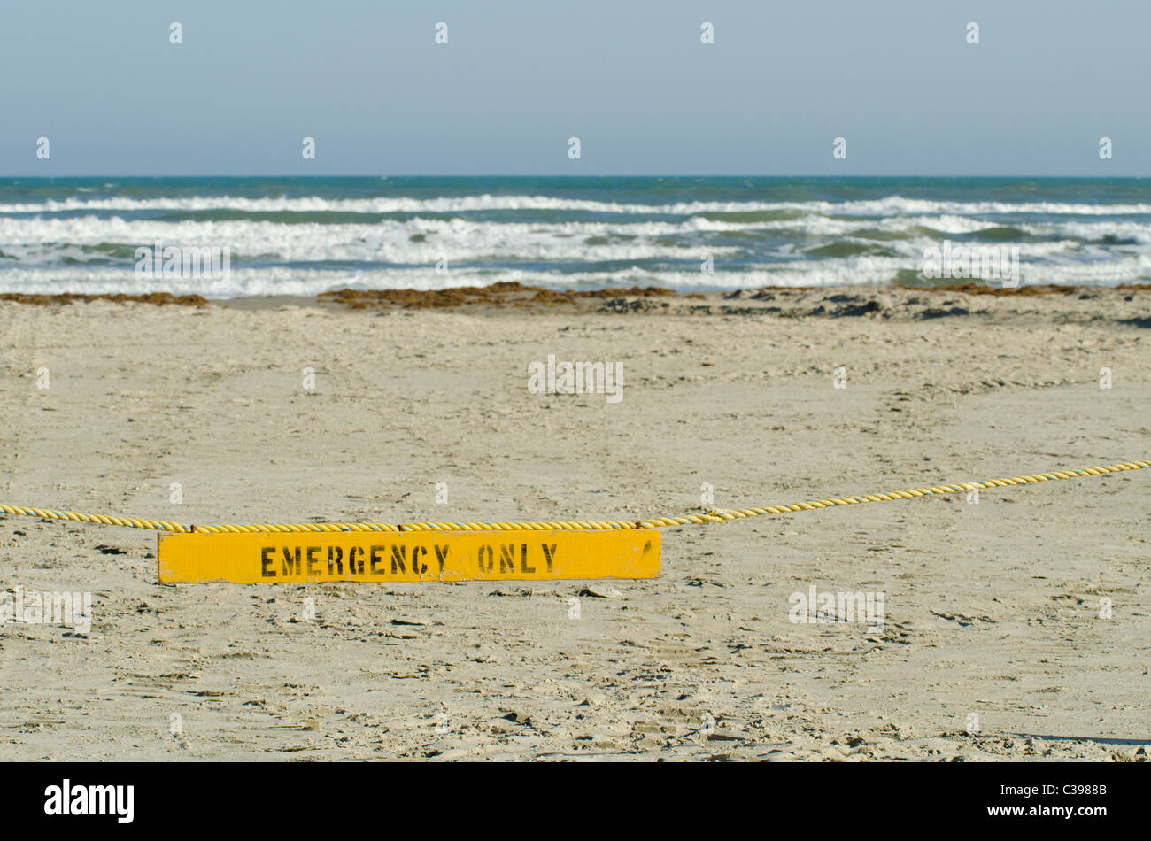Solo per emergenze segno appeso sulla corda barriera limitante il veicolo accesso alla spiaggia Foto Stock