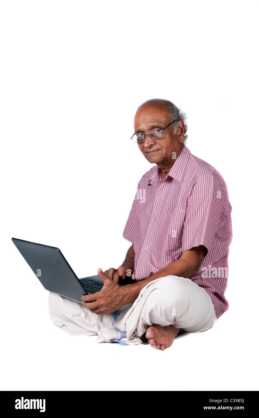 Un vecchio uomo indiano navigando in rete dopo il pensionamento Foto Stock