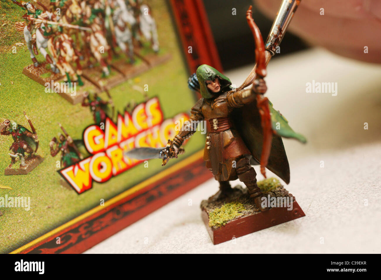 Un membro del personale dipinge una figura in un Games Workshop store. Foto Stock