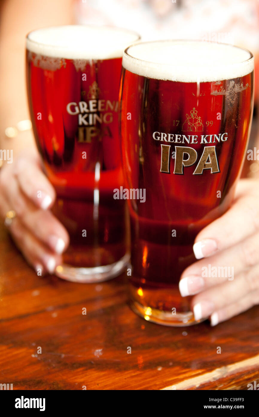 Due pinte di Greene King IPA in bicchieri di marca. Foto Stock