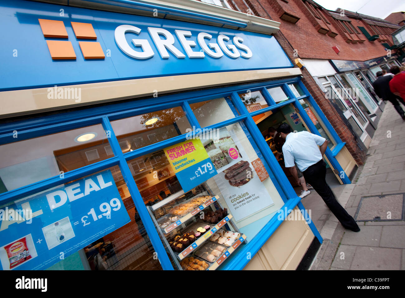 Una persona che cammina in una diramazione di Greggs il panettiere. Letchworth, 10/08/2009. Foto Stock