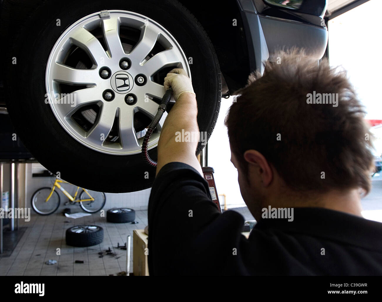 Un meccanico della concessionaria la manutenzione di un motore Honda auto. Foto Stock