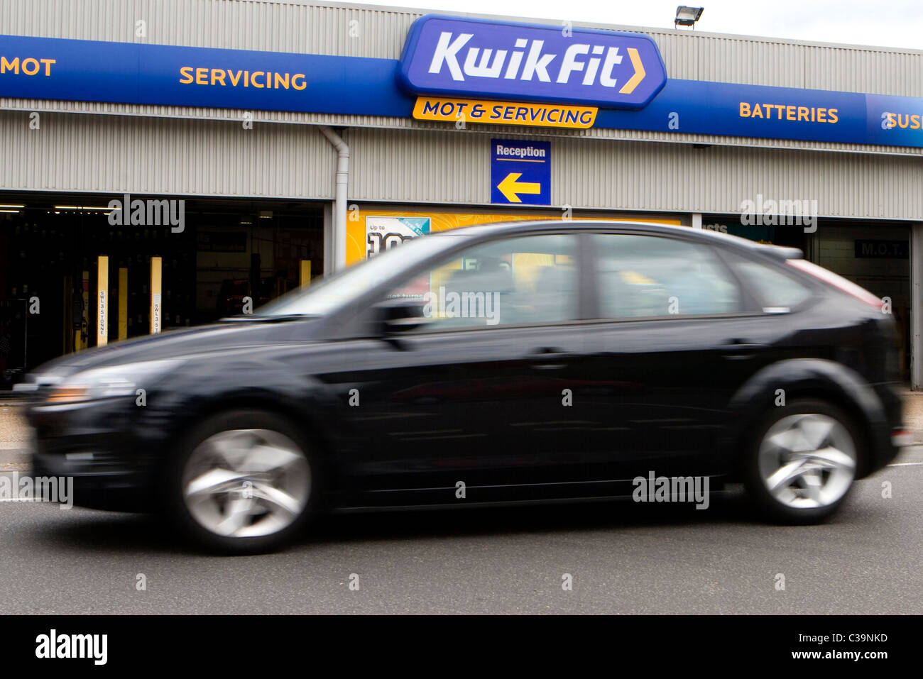 Una macchina passa una Kwik montare garage. Foto Stock