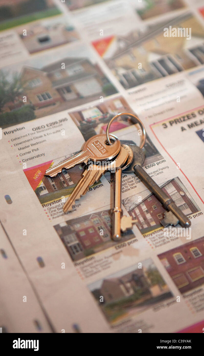 Immagine illustrativa di un set di chiavi giacente sulla parte superiore della sezione relativa alle proprietà di un giornale. Foto Stock