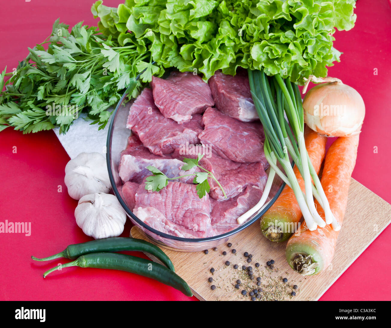 Materie di manzo con verdure su tabella rossa Foto Stock