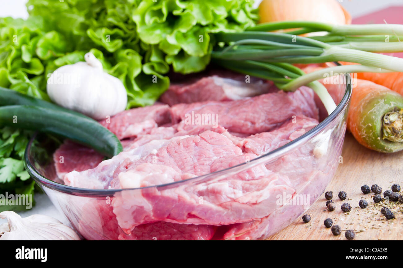 Carni bovine fresche di carne con cipolla verde, pepe, aglio e lattuga Foto Stock
