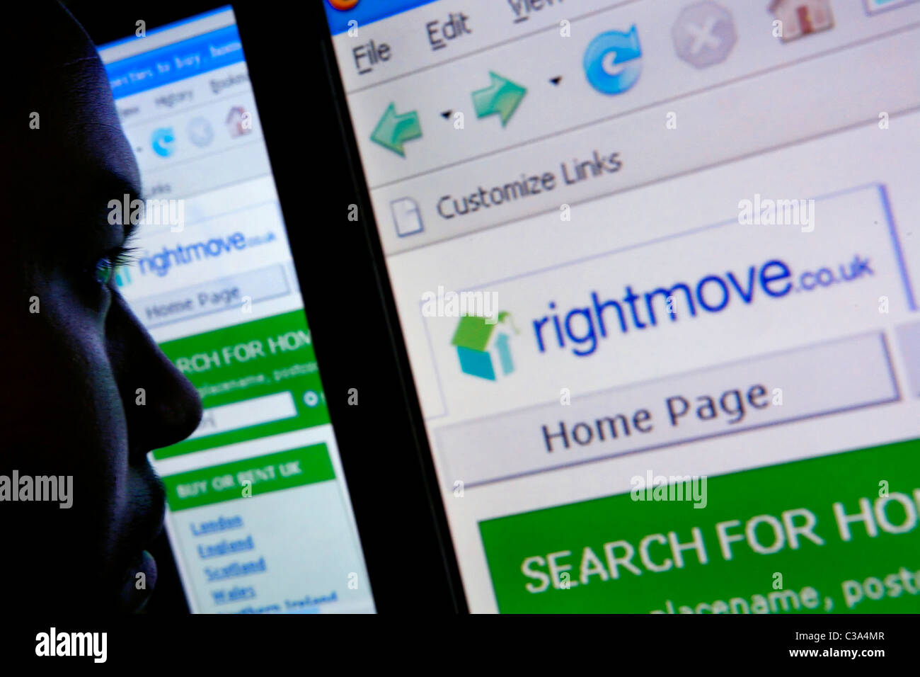 Una silhoutte di un uomo la navigazione sul sito web di Rightmove.co.uk alla ricerca di proprietà Foto Stock