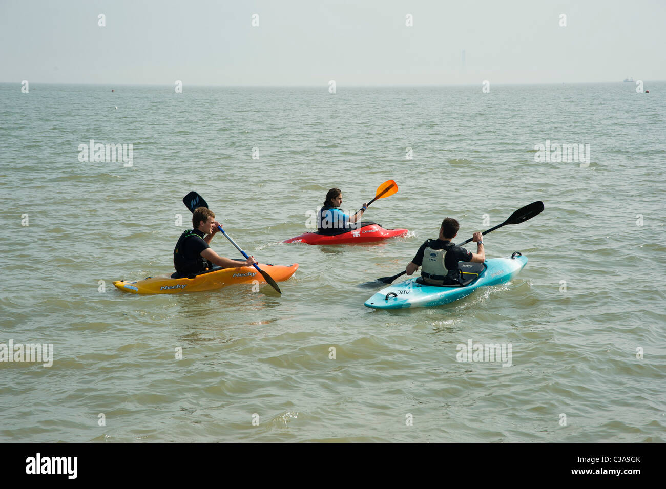 Tre persone canoa in mare Foto Stock