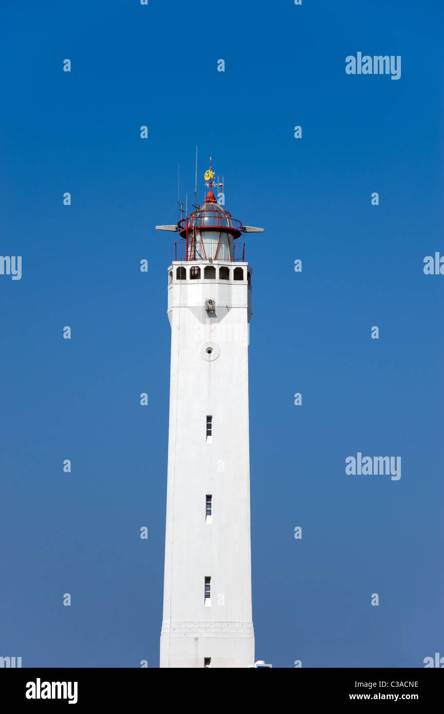 Bianco faro alto contro un cielo blu chiaro Foto Stock